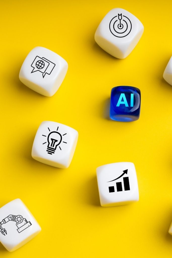 AI text and search and graph icons printed on dice against yellow
